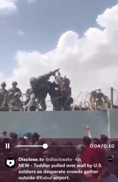 Baby is handed over the wall to American forces at Kabul’s airport.