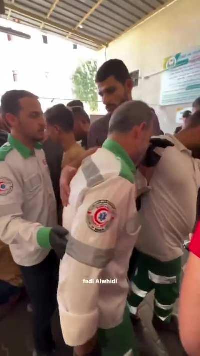 A Palestinian paramedic bids farewell to his son killed by 