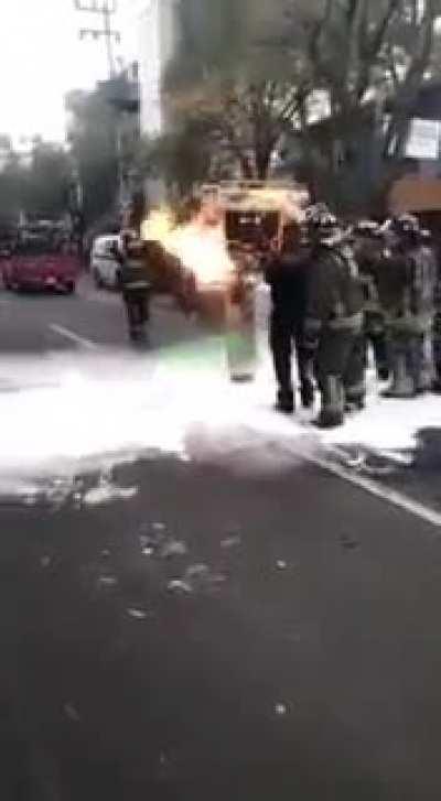 A real HERO!! Firefighter carries a gas tank out of a restaurant in Mexico city.