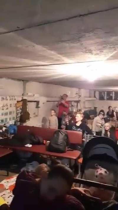 Young girl -Amelia - conforting those hiding from bombs, by providing some entertainment