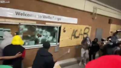 Looters breaking into a wells fargo bank