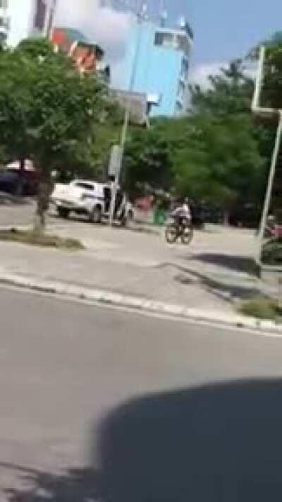 A Vietnamese traffic police officer using an ak-47 to break a window of a Chevrolet Camaro who driver showing signs of violation and disobeying the stop order of the traffic police officer and trying to turn around in order to run away.