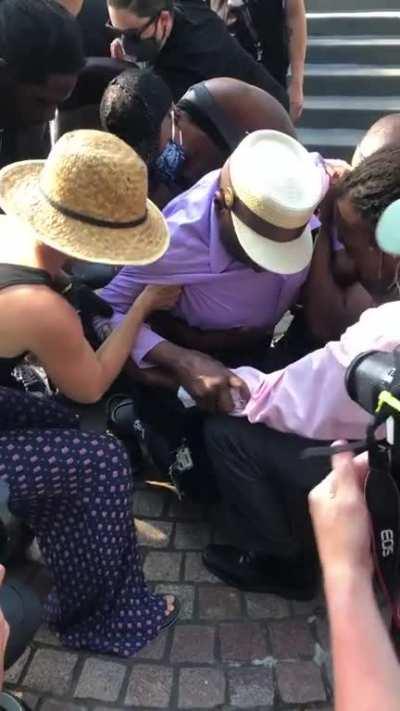 Protesters in Cincinnati assist a disabled, 73-year-old lifelong activist as he takes a knee.