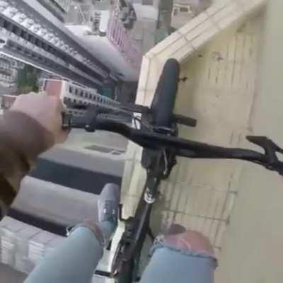 Man Rides his Bike on edge of a SKYSCRAPER