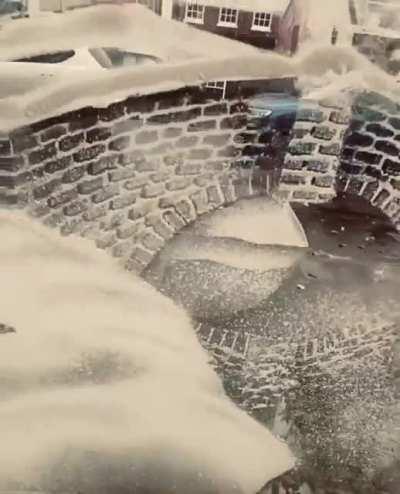 Artist uses snow spray on a window to create a snowy winter village