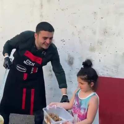 Man cooks a large amount of food and give to the people especially the poor and also the homeless person.