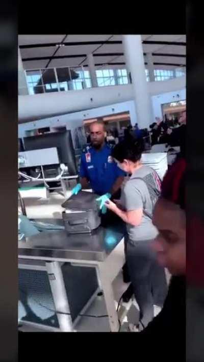 TSA agent opening the lady’s bag and finding a giant dildo