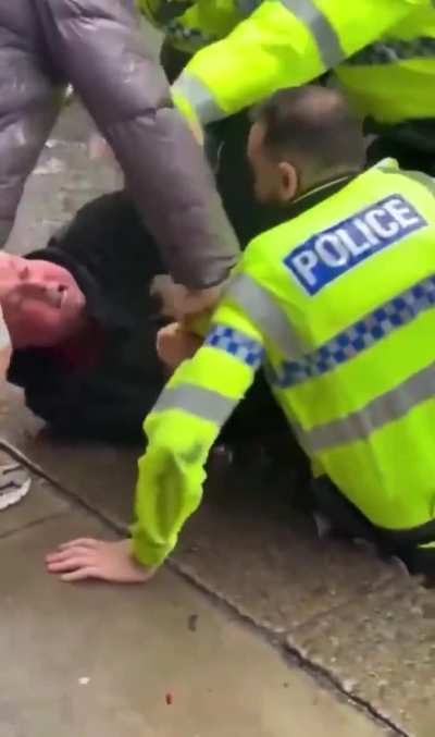 Liverpool fans attempting to reach the attacker as he is being arrested and placed into a police van.