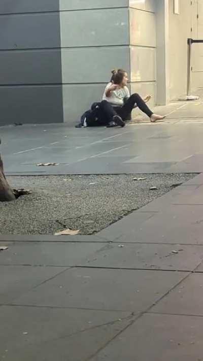 Wired lady conjuring several conversations with herself out front a closed Kmart