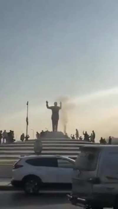 Syrians destroying the statue of their previous ruler after their success in bringing down the dictatorial regime
