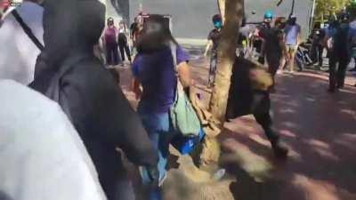 Black bloc steal a woman's thin blue flag at a rally in San Francisco