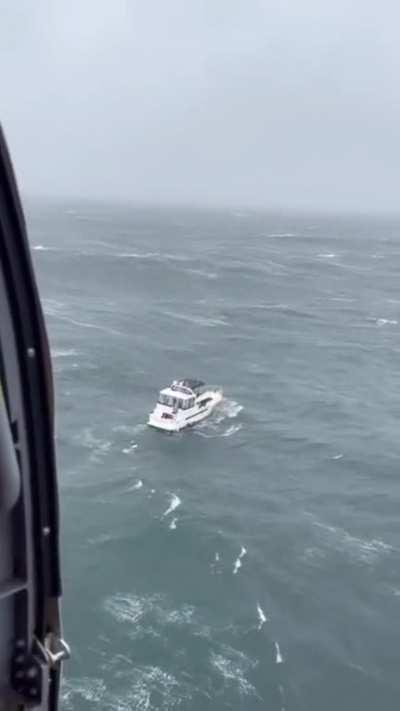 USCG rescue swimmer conducting a rescue in what appears to be moderate waves, nothing too extreme. But then chaos ensues