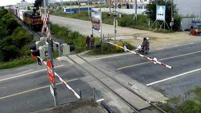 Cambodian dude just ride his motor past the train barricade as if nothing was there....