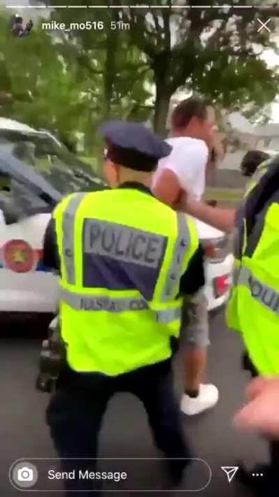 East Meadow, NY: a police officer abruptly stops walking so a protestor walking behind him will bump into him, so the other police can attack and arrest him.