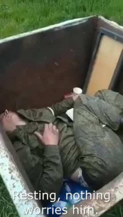Drunk russian soldier sleep in the trash container.