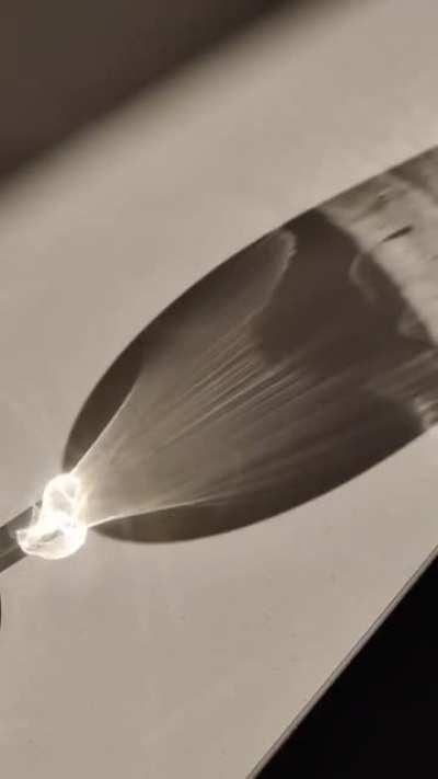Sunlight refracting through a glass of fluid recorded in slow motion