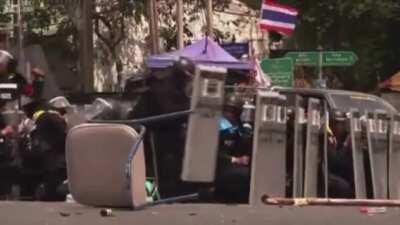 Thai police officer tries to kick a grenade that was thrown at them.