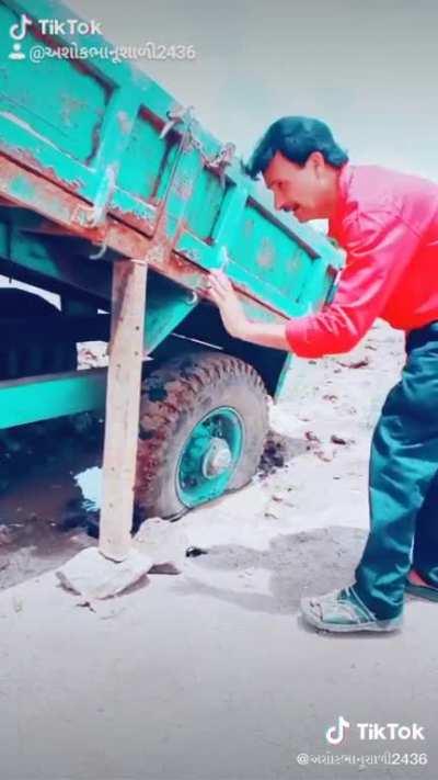 Using a 2x4 to get dump truck out of the mud