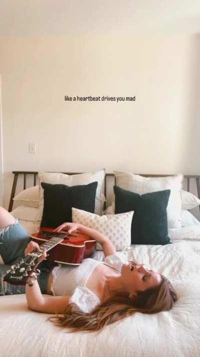 Playing a song on her guitar on the dreamiest bed of all time (May 2023)