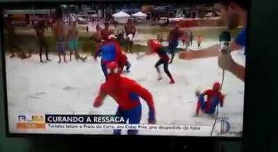 A reporter was talking about the amount of poeple coming to the beach when a group of spider-mans came into frame dancing, jumping and rolling