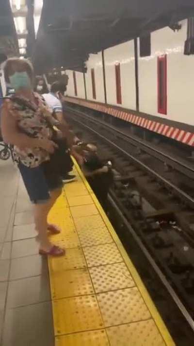 A man jumps on to the tracks to help a man in a wheelchair who fell on the subway tracks. He was pulled to safety while a train was about 10 seconds away from entering the station.