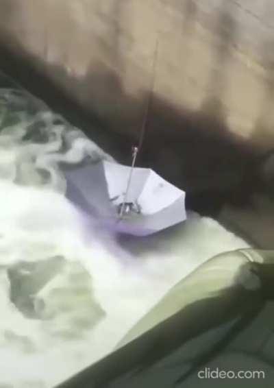 Quick! the mods are asleep. Upvote this man fishing at a Dam with an umbrella.