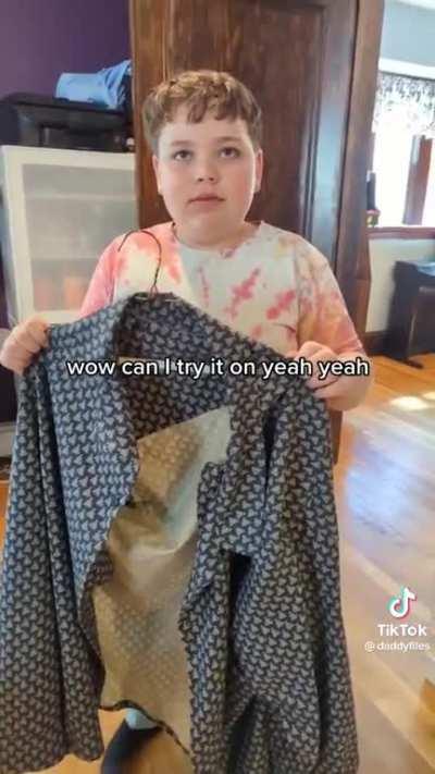 Dad tries on a shirt sewed by his young son