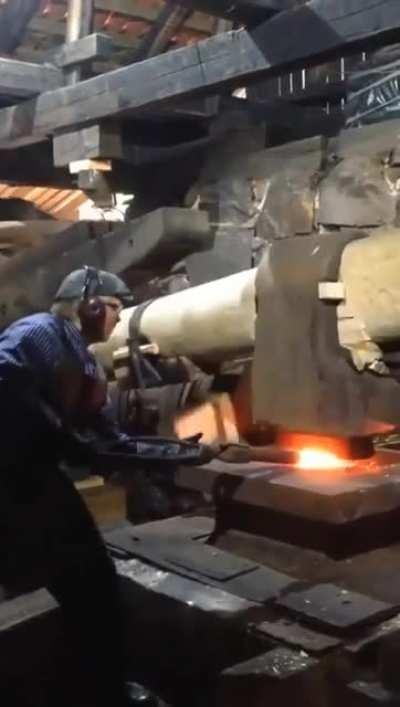 Old school mechanics for this forging hammer. Looks like it is actually powered by a water wheel.