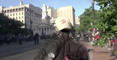 Hero protestor peacefully blocks a riot control grenade with his face