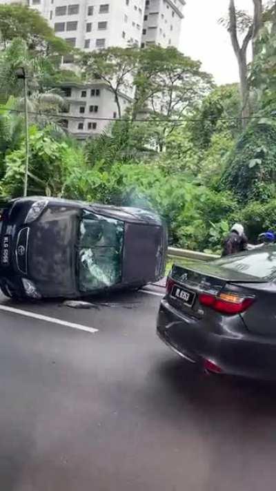 Just happened on the Salak highway heading to mid valley - this car was running from police , hit another car , flipped violently . A guy crawled out the top and was tackled by a motorbike police and another Good Samaritan on a motorbike. What a exciting 