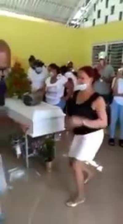 People dancing and fighting during the funeral