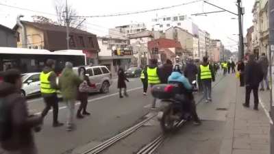 Car drives through protestors in Serbia