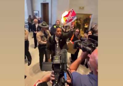 TN State Rep Justin Jones burns a print out of the confederate flag after the republican supermajority voted to break up Memphis’ congressional district which was the only democrat and majority black district in the entire state