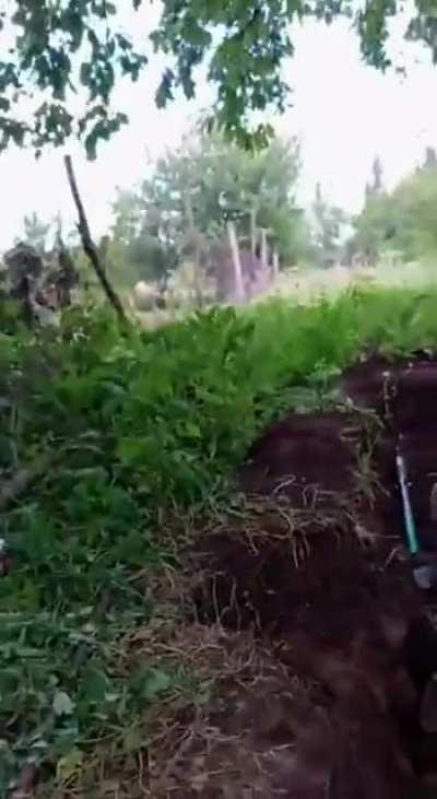 RU POV: A farmer casually digs up his potatoes, while Ukrainian troops cower together in a trench confused. 