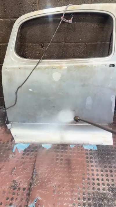 Pressure washing the paint off this Hudson door after a chemical paint removal dip.