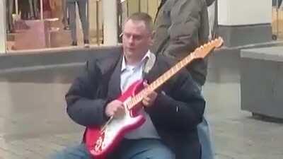 A blind man playing you'll never walk alone in Liverpool city centre
