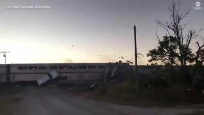 Amtrak train slams into a semi hauling vehicles, sending vehicles flying 