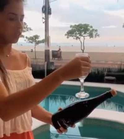 This woman popping a cork with a glass trick.