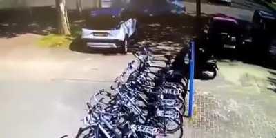 A crazy man on bike, hits many bicycles standing in parking. Found instant karma