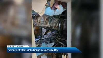 Truck crashes into side of a house