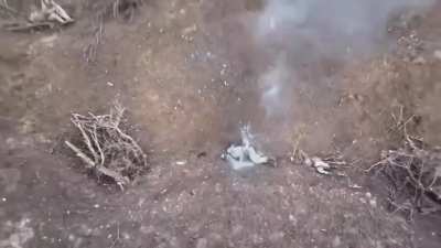 A Russian soldier directs a Ukrainian drone to attack his own comrade, indicating he is pretending to be deceased. Eastern Ukraine, 12/25/2023