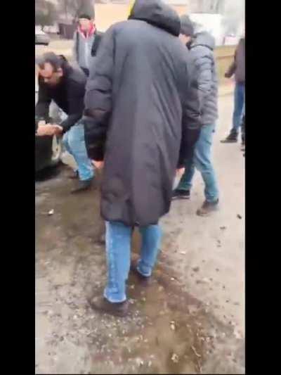 Close up perspective of Tank crushing the car + Ukrainian civilians trying to free the old man