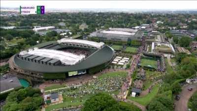A Just Stop Oil protester throws jigsaw puzzle pieces onto a tennis court during a Wimbledon match