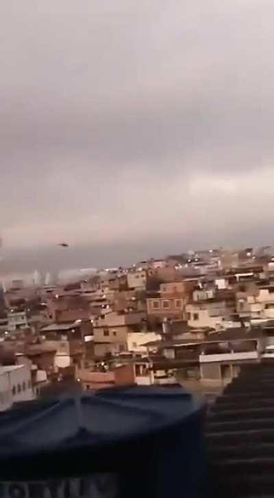 Brazil, Complexo do Alemão, a favela in Rio de Janeiro, heavily armed criminal shoots at a police helicopter