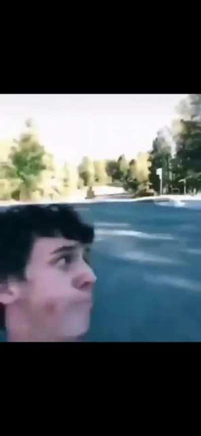 Man drinks milk while going backwards on a skateboard