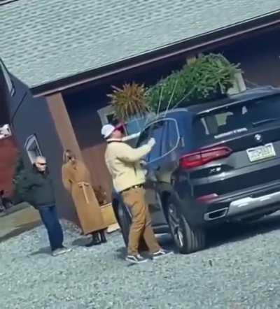 Man tying a tree to his car