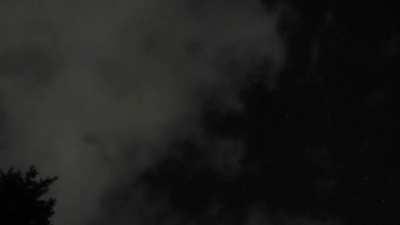Bright orb-like object spotted flying behind the clouds.