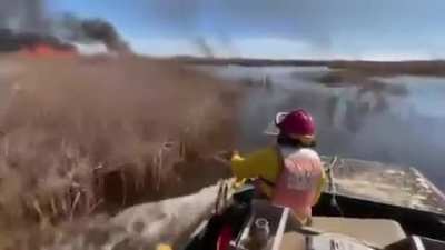 US Fish and Wildlife employee uses a flamethrower to set the marshland on fire