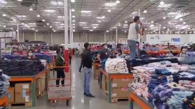 California man using megaphone in Costco to say Covid is the Flu while standing on a clothing display (Tustin, CA)