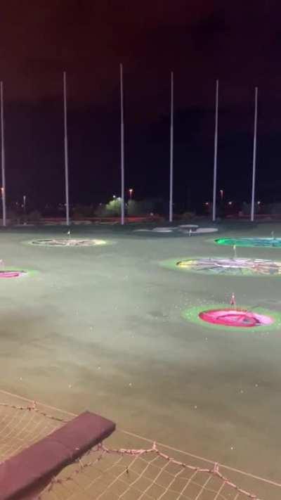Guy runs out on field at topgolf while people are still hitting golf balls